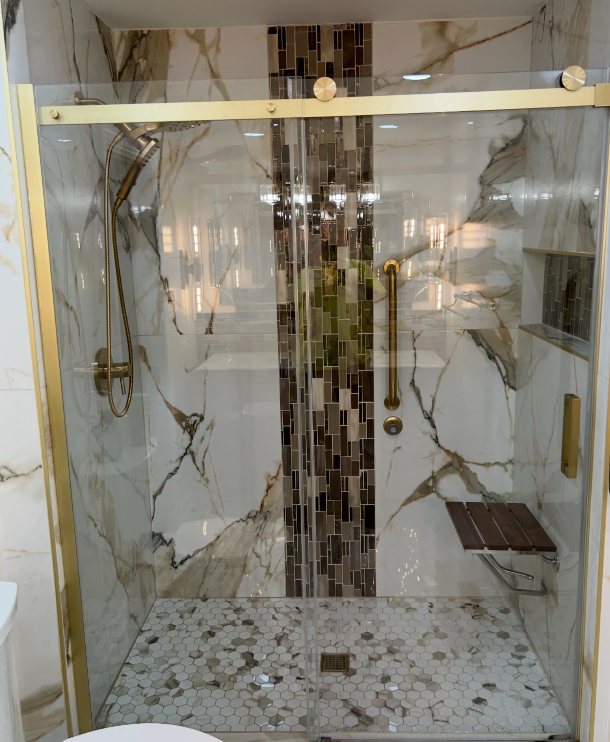 Luxury walk-in shower with marble tile and brass fixtures