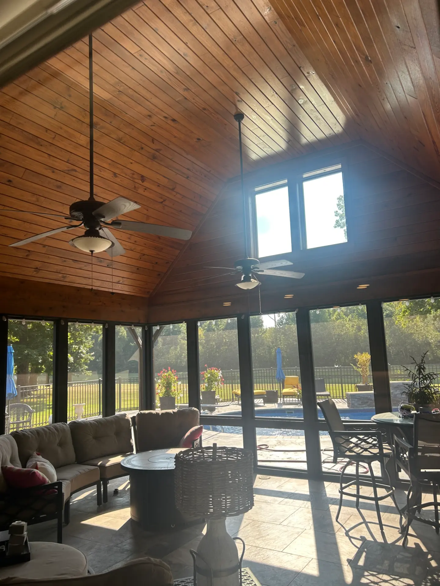 Screened sunroom with wood ceiling overlooking a pool