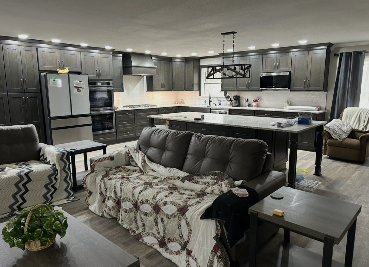 Open-concept kitchen and living space with dark cabinets